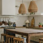 Een landelijke keuken kiezen: tijdloze charme voor uw woning Landelijke keuken met houten tafel en koperen pannen