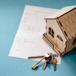 Augmentation de loyer en Belgique : maquette de maison, cles et contrat de bail sur une table / Huurverhoging in Belgie: huisje, sleutels en huurcontract op tafel