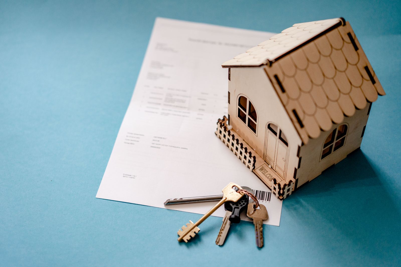 Augmentation de loyer en Belgique : maquette de maison, cles et contrat de bail sur une table / Huurverhoging in Belgie: huisje, sleutels en huurcontract op tafel